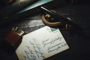 Vintage handwritten letter with a fountain pen and pocket watch.