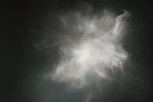 Abstract cloud of white powder or smoke against a dark background.