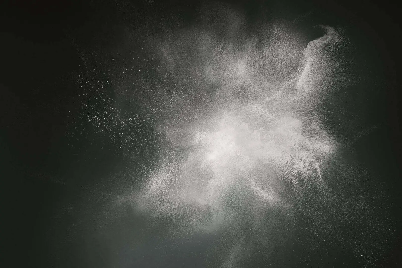 Abstract cloud of white powder or smoke against a dark background.