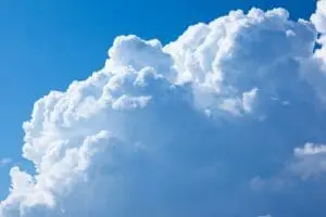Fluffy white clouds against a bright blue sky.
