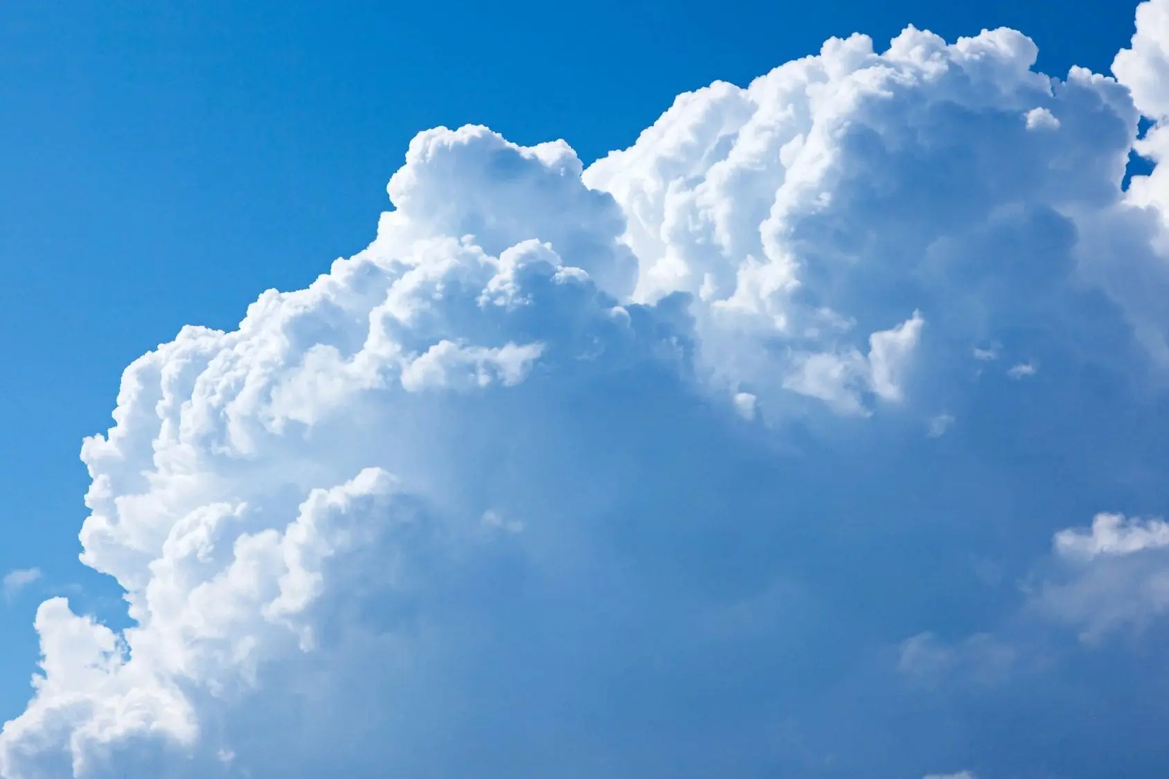 Fluffy white clouds against a bright blue sky.