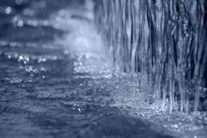 Close-up of water flowing down a surface creating ripples.