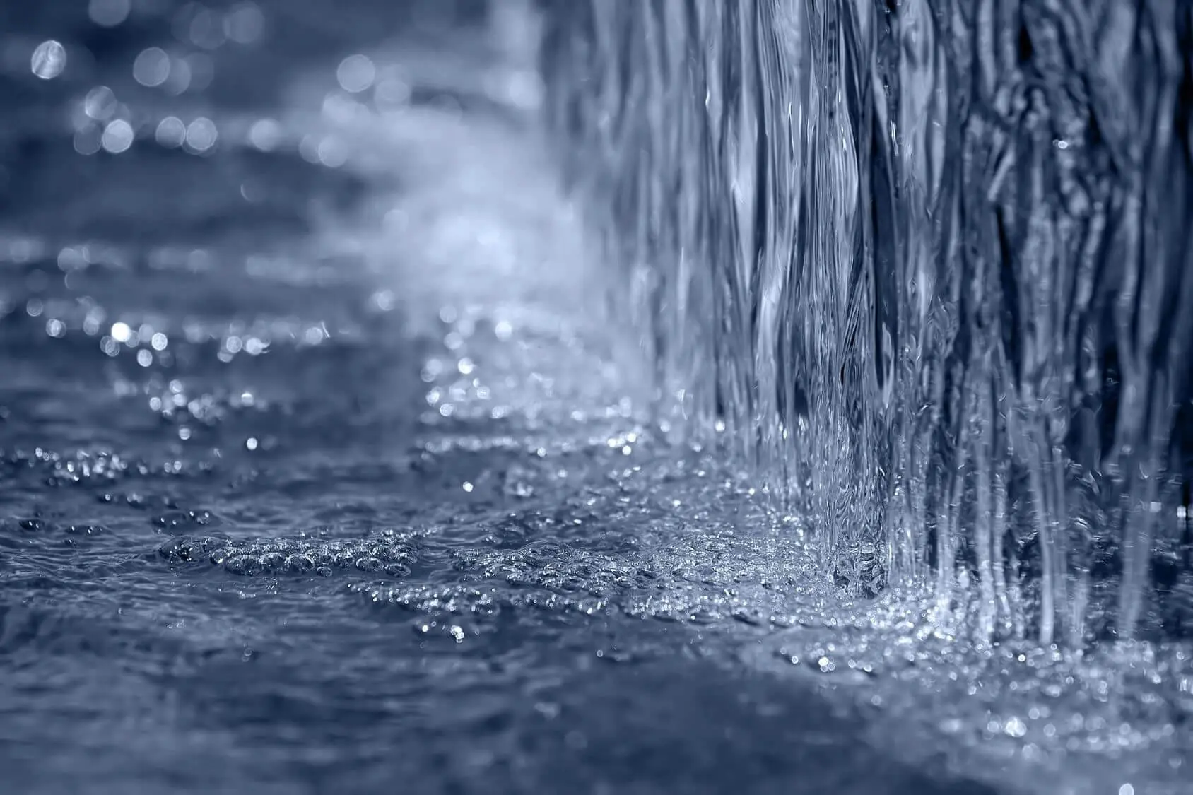 Close-up of water flowing down a surface creating ripples.