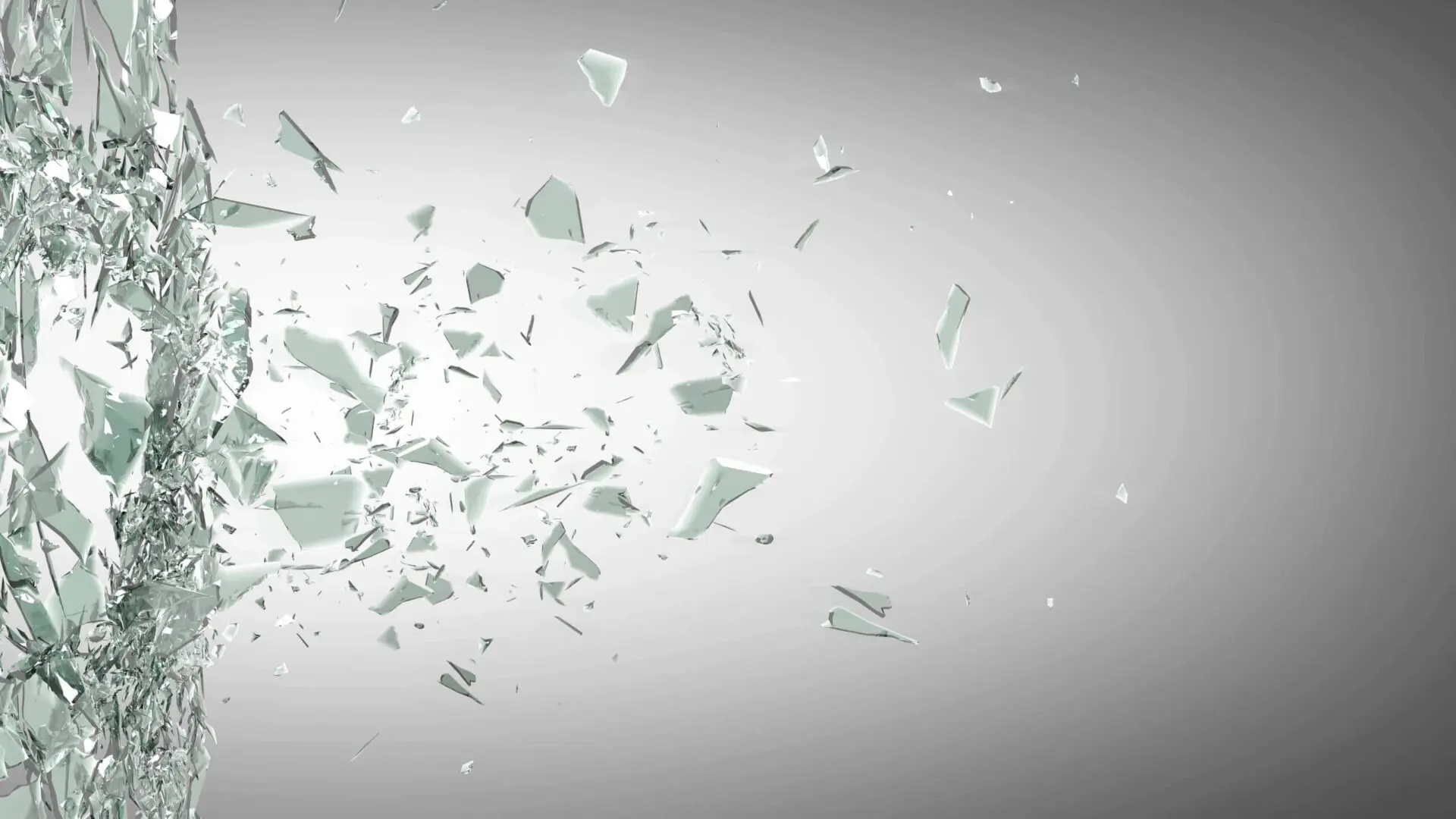 Glass shards shattering mid-air against a gray background.