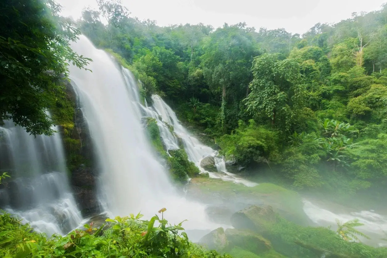 A large waterfall cascading through lush green forest.