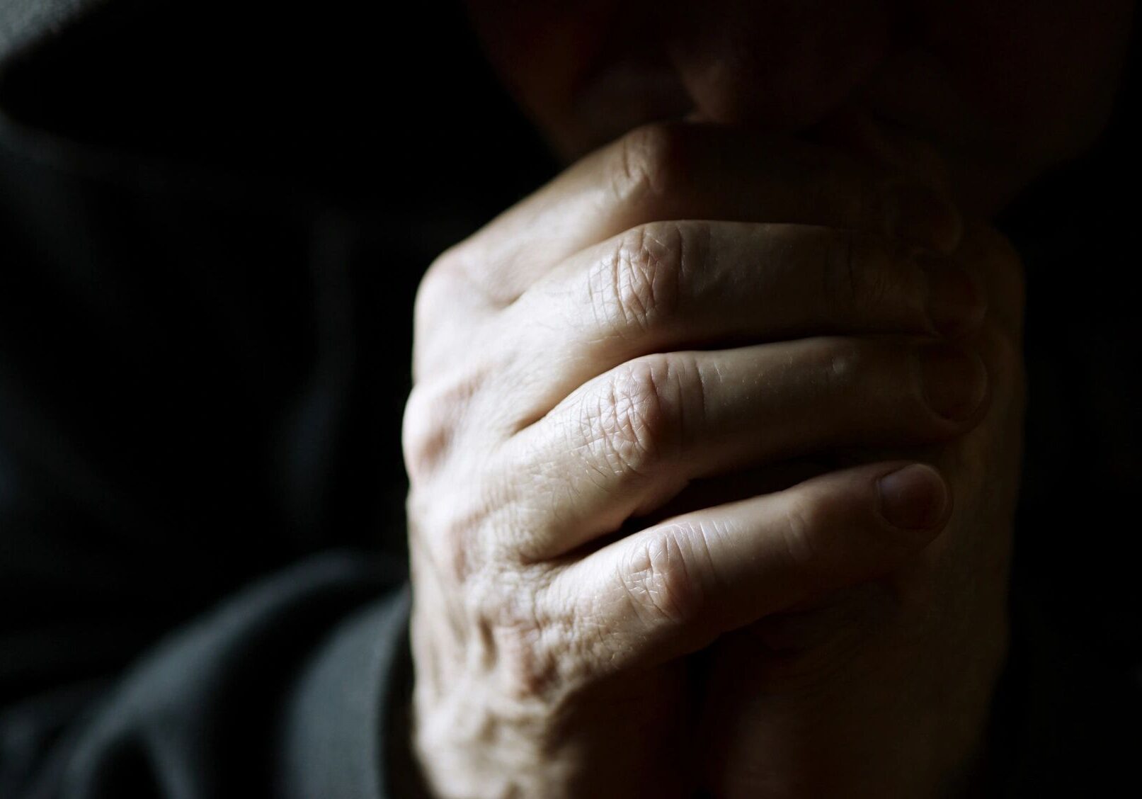 A close-up of an elderly hand with visible wrinkles and texture.