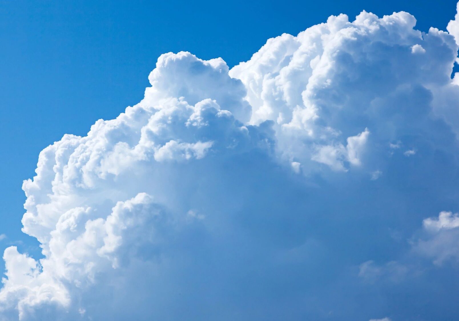 Fluffy white clouds against a bright blue sky.