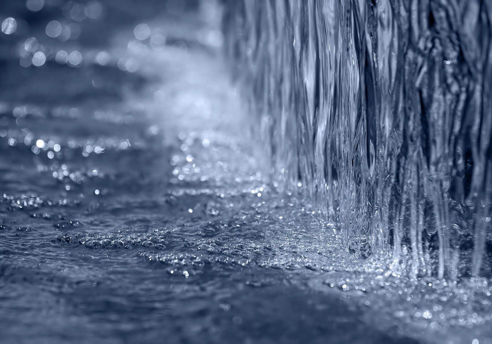Close-up of water flowing down a surface creating ripples.