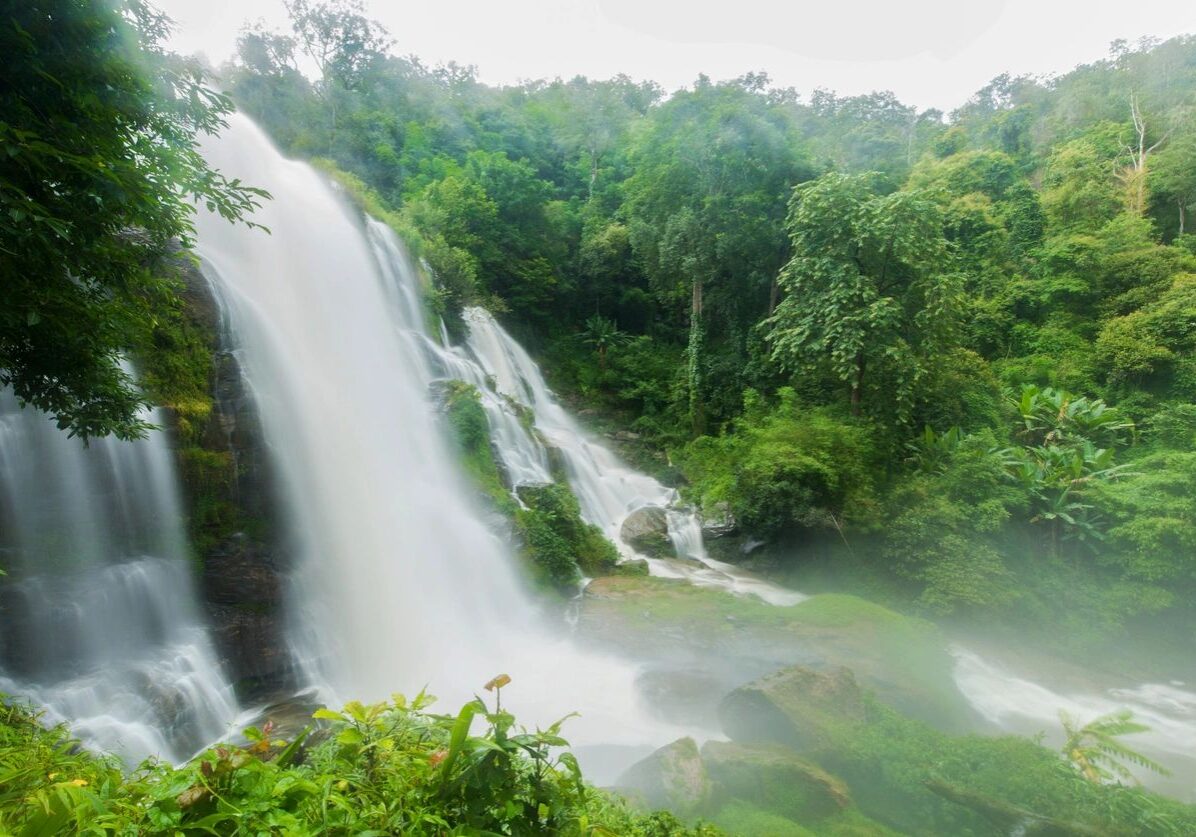 A large waterfall cascading through lush green forest.